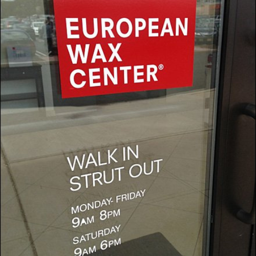 European Wax Center door sign: Walk in, strut out
