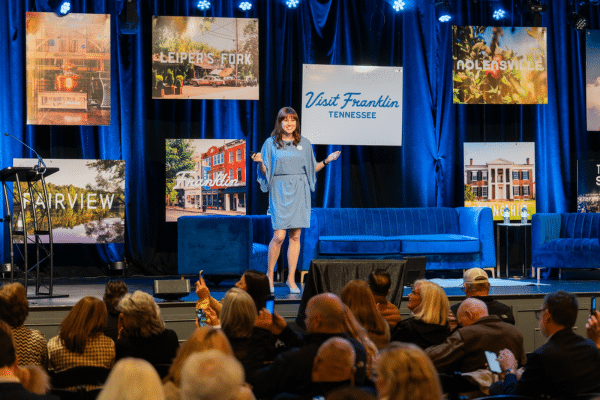 Brittany Hodak speaking on stage at a corporate event in Franklin, TN