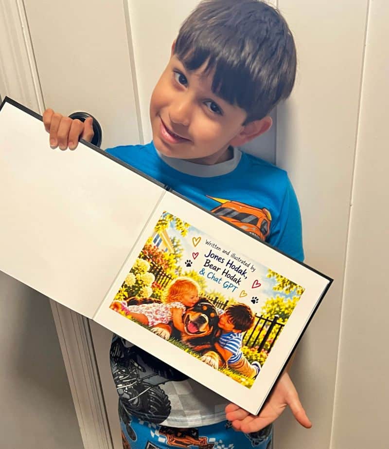 Brittany's six-year-old son posing with the children's book he made using AI